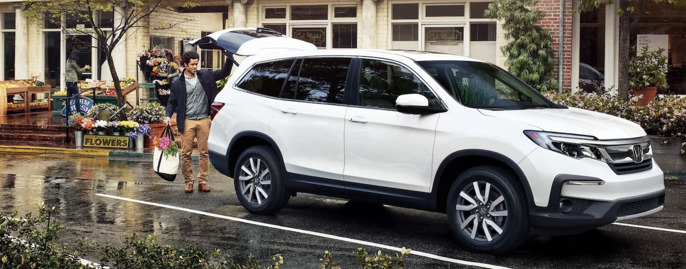 A white 2022 Honda Pilot EX-L is shown parked in front of a building.