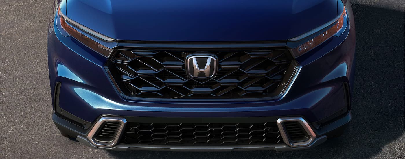 A close up of the grille on a dark blue 2023 Honda CR-V Hybrid is shown.