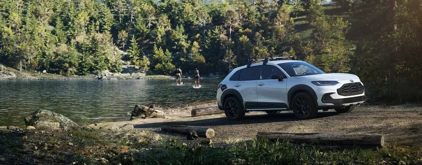 A white 2024 Honda HR-V Sport is shown parked next to a lake.
