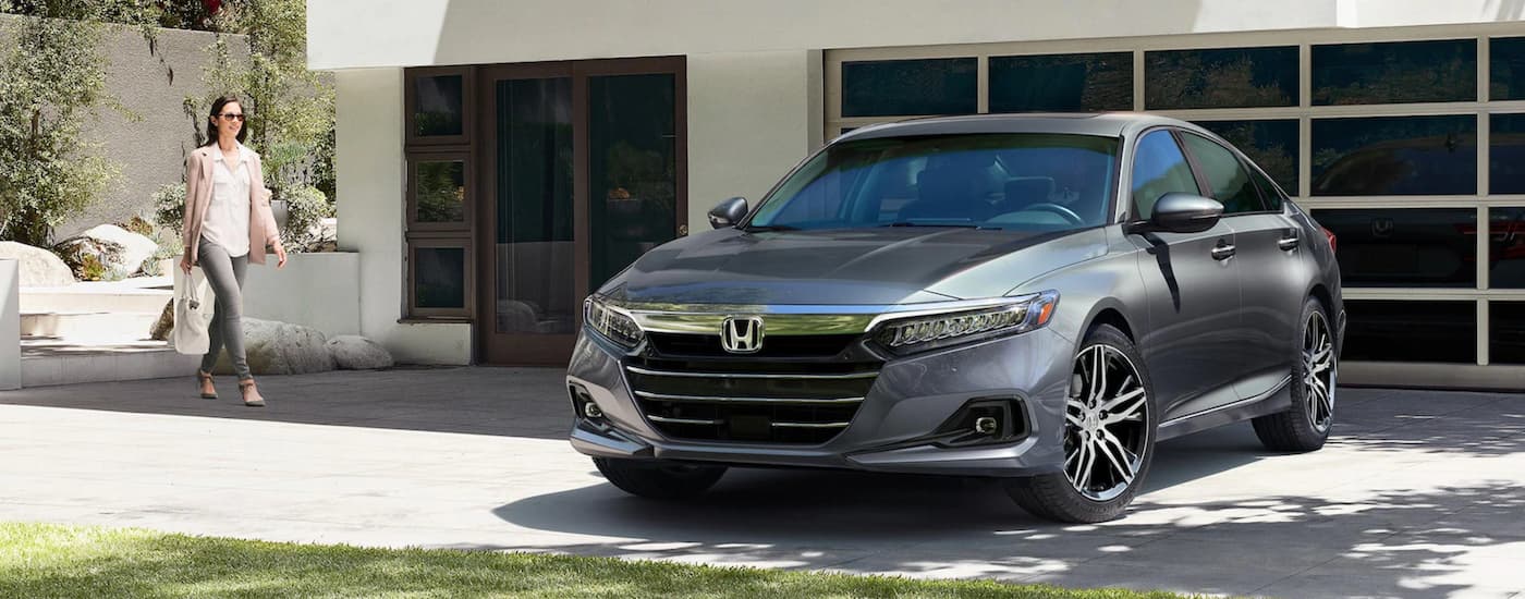 A grey 2021 Honda Accord Touring is shown parked in a driveway after viewing used cars for sale in Midland.