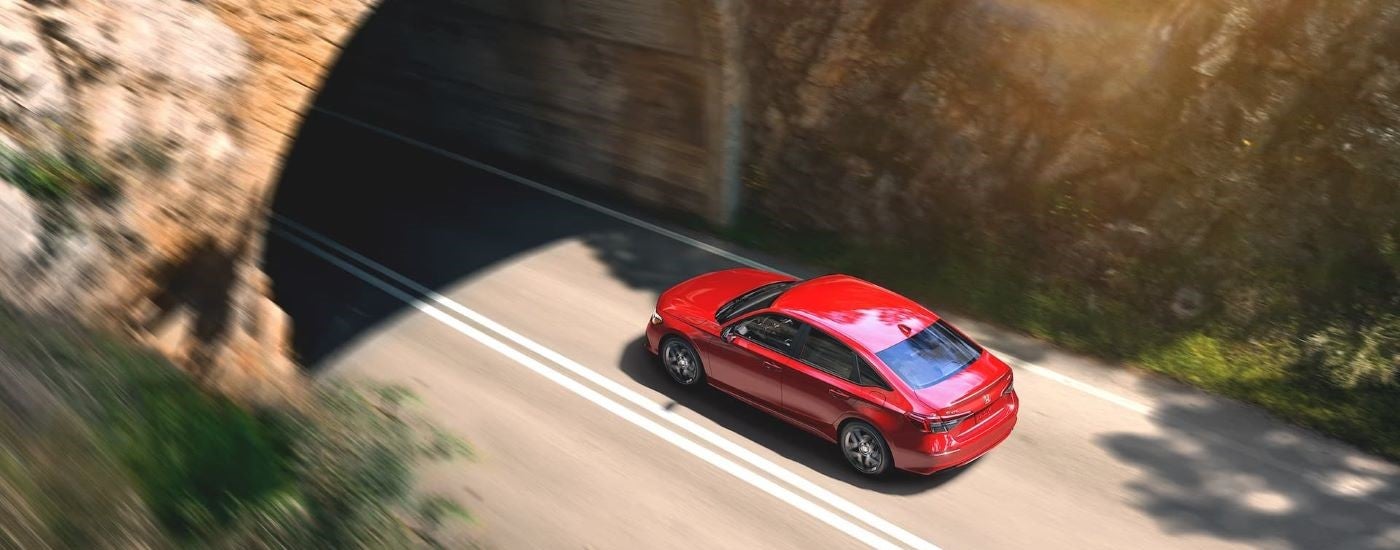 A red 2023 Honda Civic is shown from above while entering a tunnel.