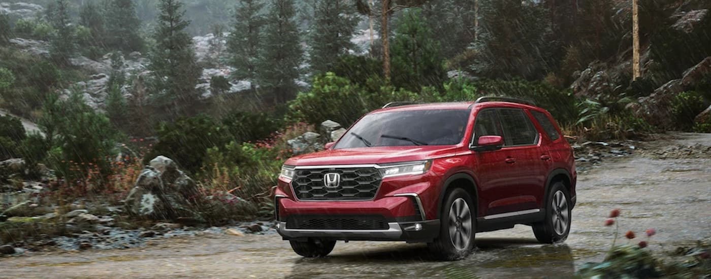 A red 2023 Honda Pilot is shown from the front at an angle after leaving a dealer that has used SUVs for sale near Big Spring.