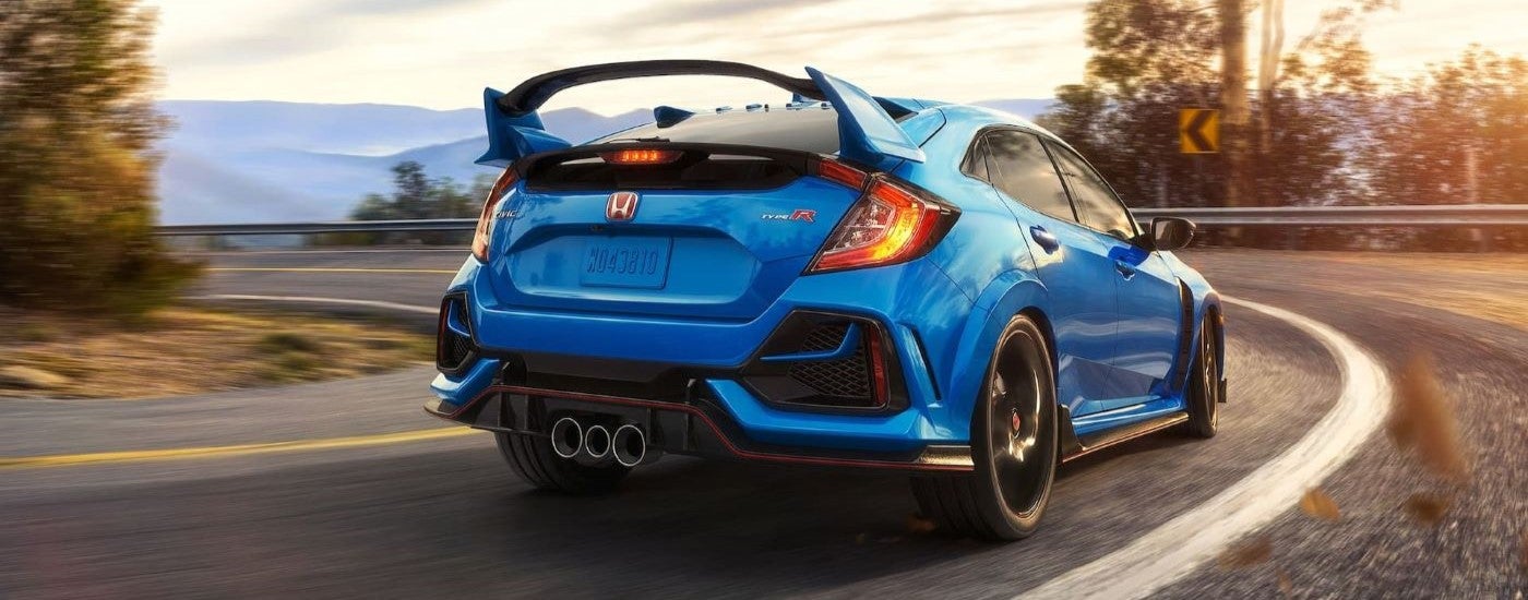 A blue 2021 Honda Civic Type R is shown rounding a corner.