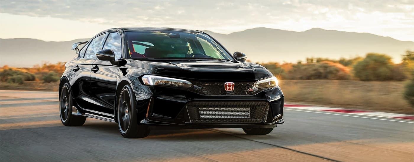 A black 2023 Honda Civic Type R is shown on a race track after leaving a used Honda dealership.
