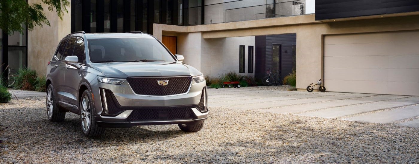 A grey 2020 Cadillac XT6 Sport is shown parked on a gravel driveway.