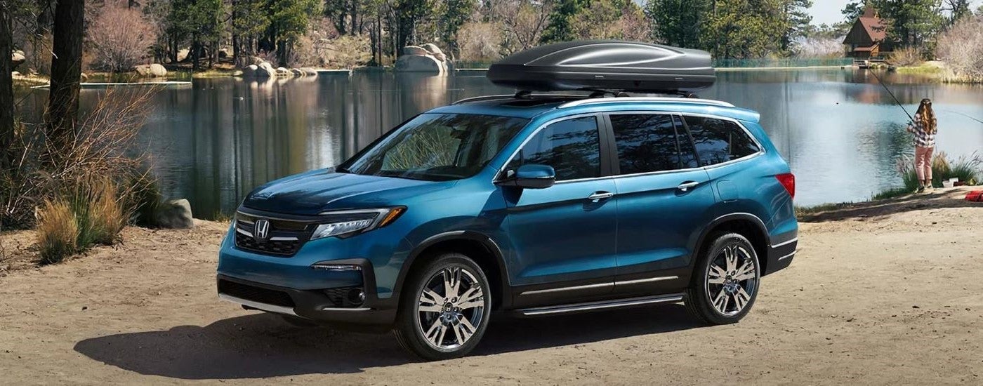 A blue 2021 Honda Pilot Elite is shown from the front at an angle.