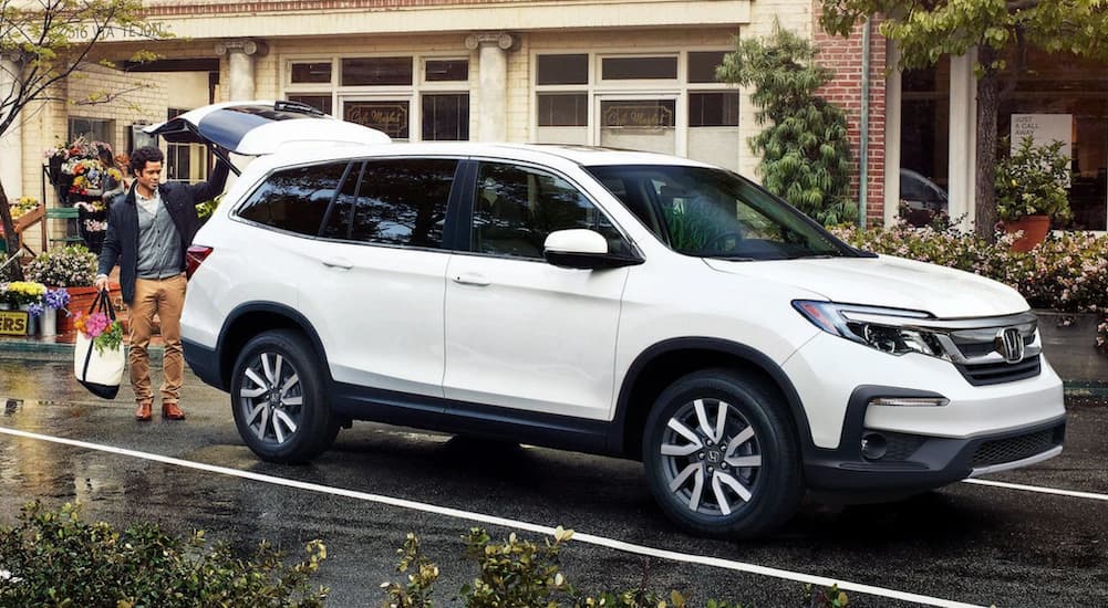 A white 2021 Honda Pilot is shown from the front at an angle.