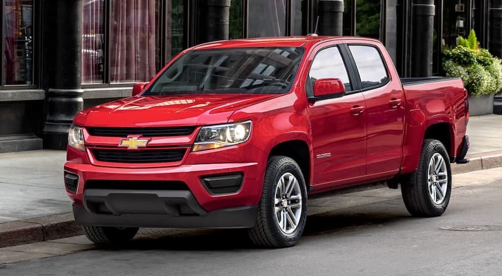 A red 2019 Chevy Colorado is shown parked on the side of a city street after viewing used trucks for sale near Big Spring.