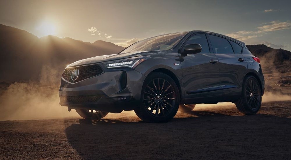 A grey 2022 Acura RDX A-Spec parked in front of mountains on a sunny day.