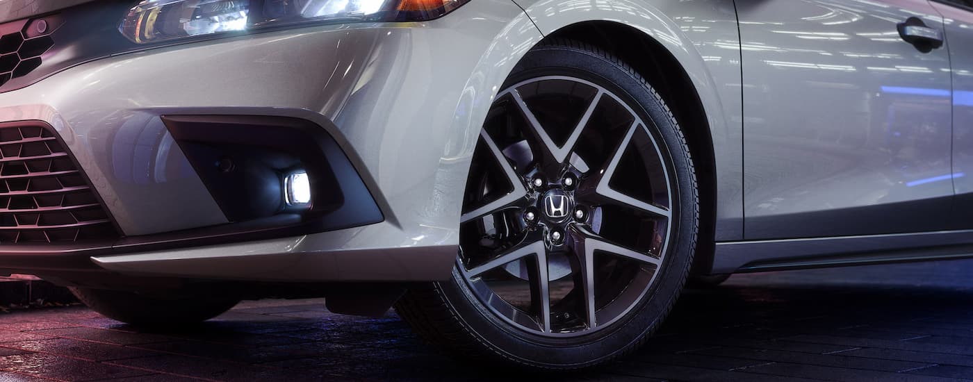 A close up of the tire and rim on a grey 2024 Honda Civic Hatchback Sport Touring is shown.