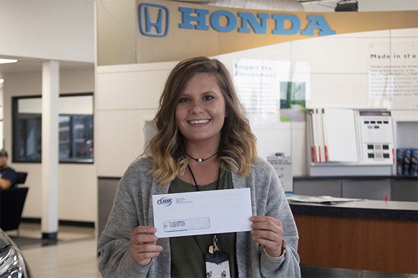 Midland, Texas Female Teacher Holding Donation from Honda Dealer