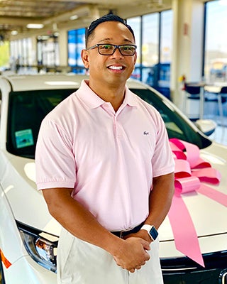 Midland Honda Dealer Staff Member in Pink Shirt in Front of a White Sedan for Sale