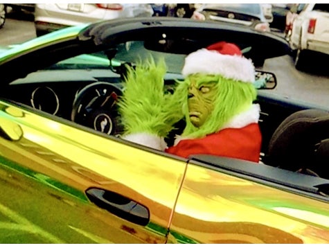 Grinch in a Santa Suit Driving a Green and Black Mustang
